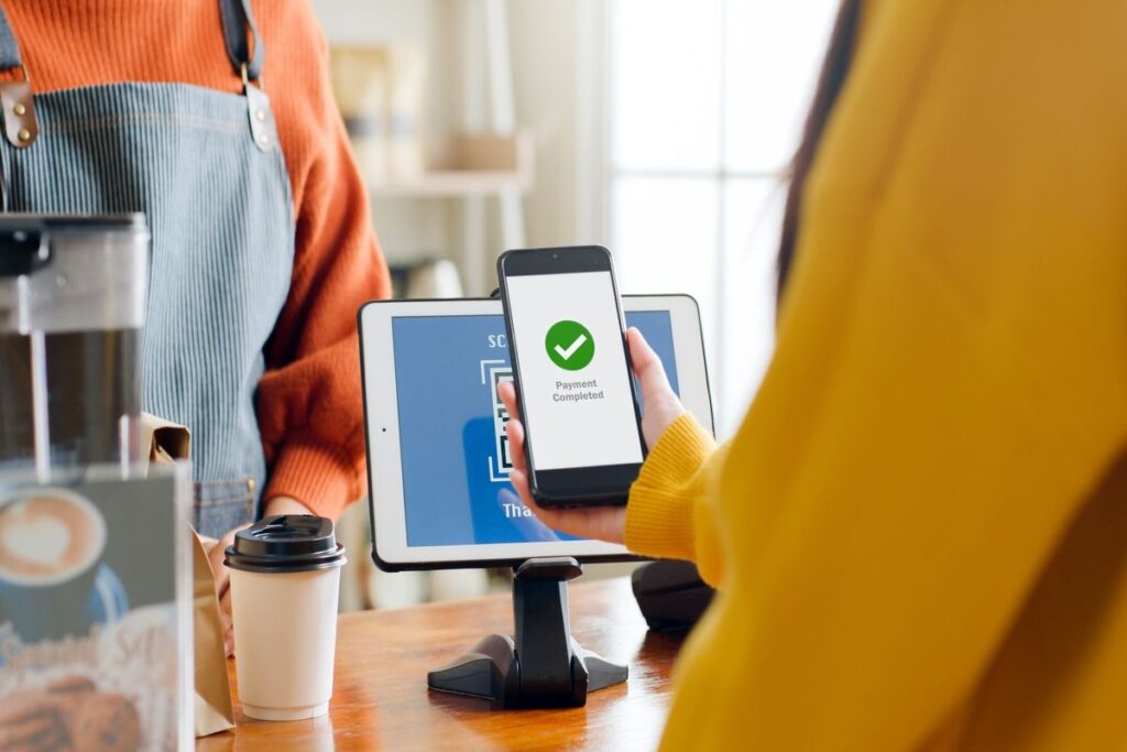 Mulher pagando conta do restaurante com a sua carteira e-wallet.