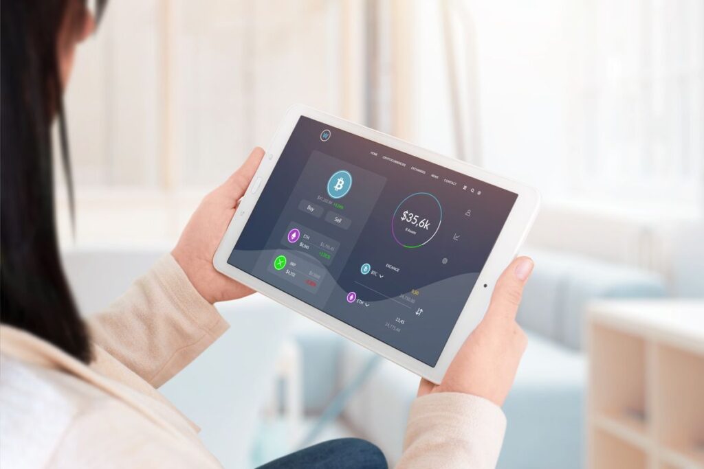 Mulher acessando a e-wallet de criptomoeda pelo tablet em casa.