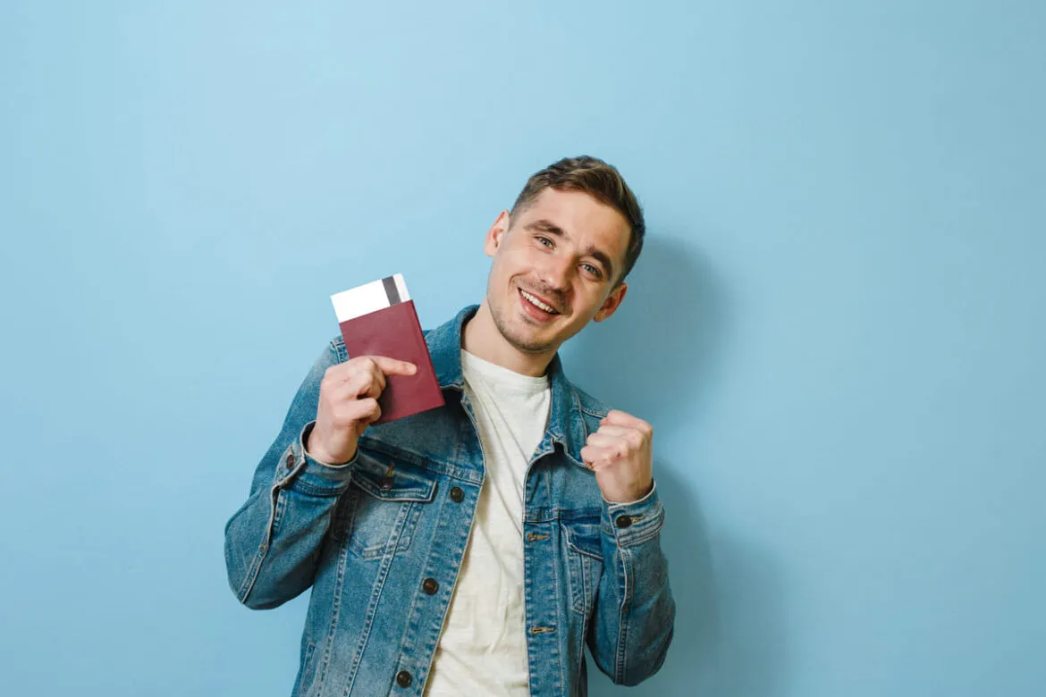 Homem segurando passaporte após saber como comprar passagem barata em cima da hora.