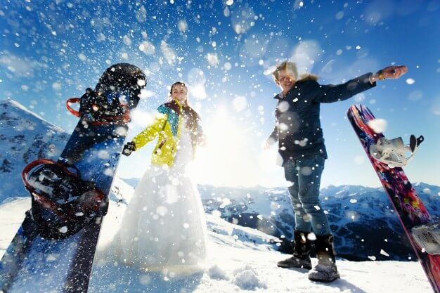 Destinos na América do Sul: Homem e mulher em pés na neve, vestidos para praticar snowboard. 