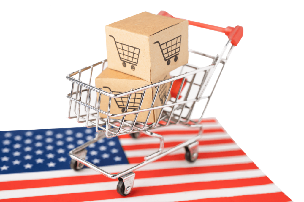 Carrinho de compras com duas caixas de papelão dentro em cima da bandeira dos Estados Unidos