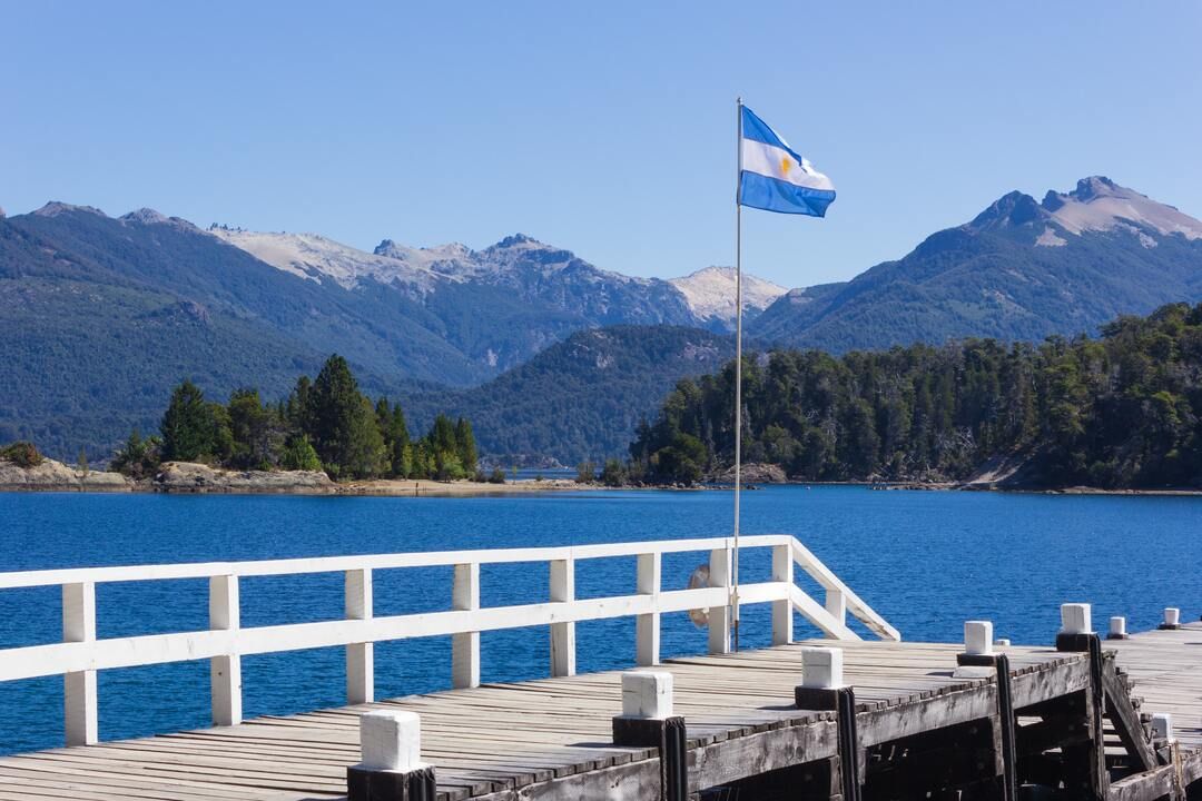 quanto custa uma viagem para argentina: passarela com o mar em volta com a bandeira da argentina