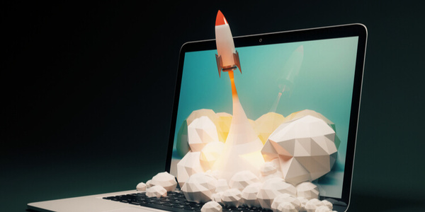 Um notebook com a imagem de um foguete, símbolo de crescimento, saindo da tela para o mundo real