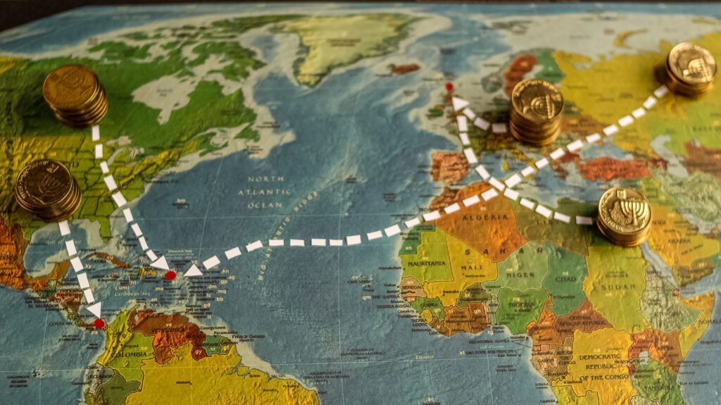 Um mapa mundi onde alguns países são sinalizados com moedas e setas ligando uns aos outros