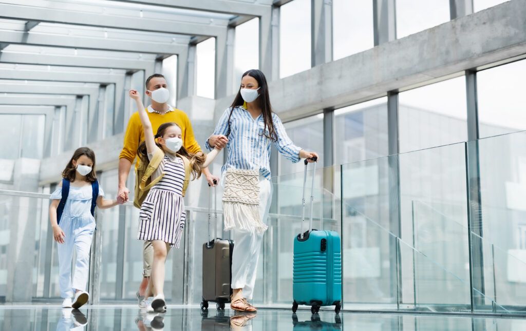 Família no aeroporto usando mascaras contra a covid