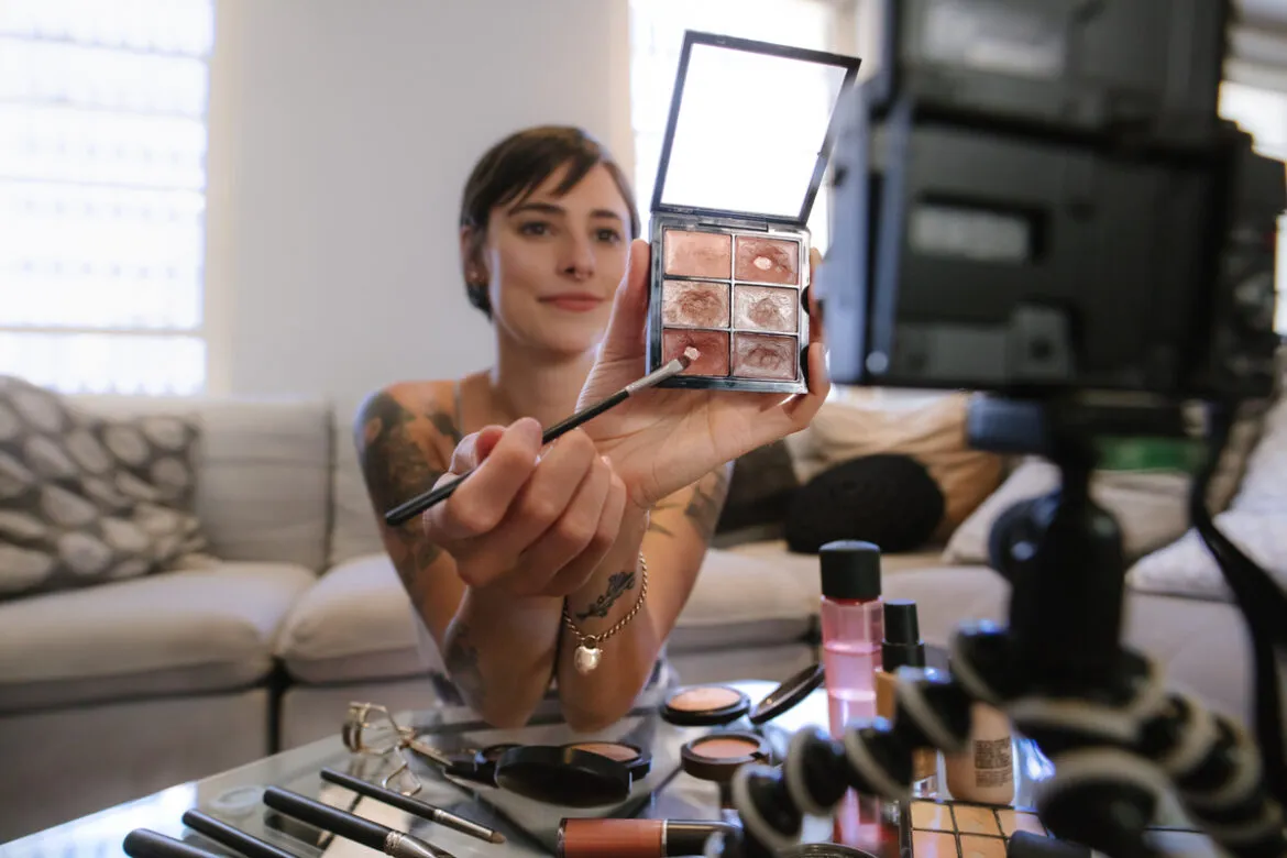 Mulher, gravando vídeo de make up, se quesitando sobre quanto ganha um youtuber iniciante.