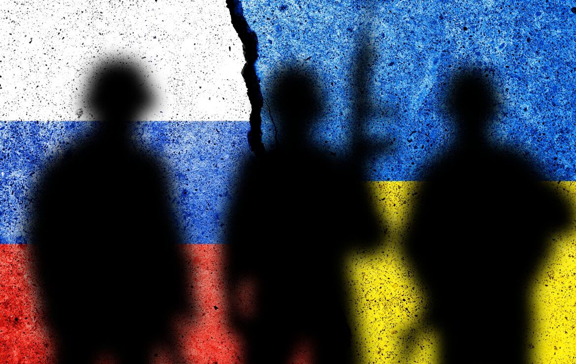 Bandeira Rússia e Bandeira Ucrânia com sombra de homens armados