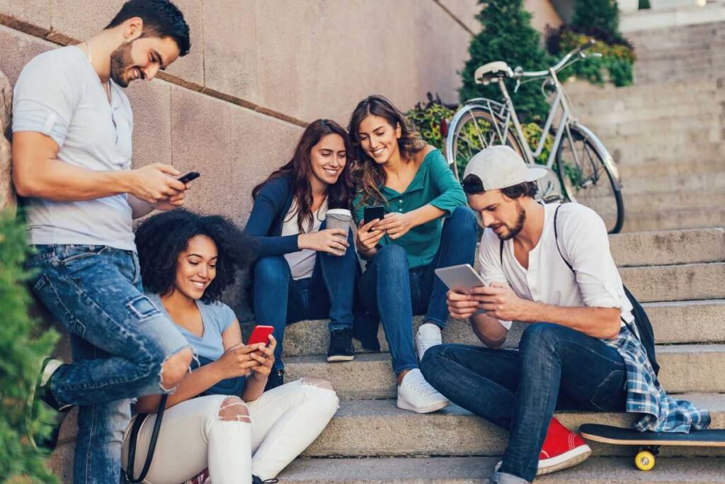 Grupo de jovens acessando a internet pelo celular.