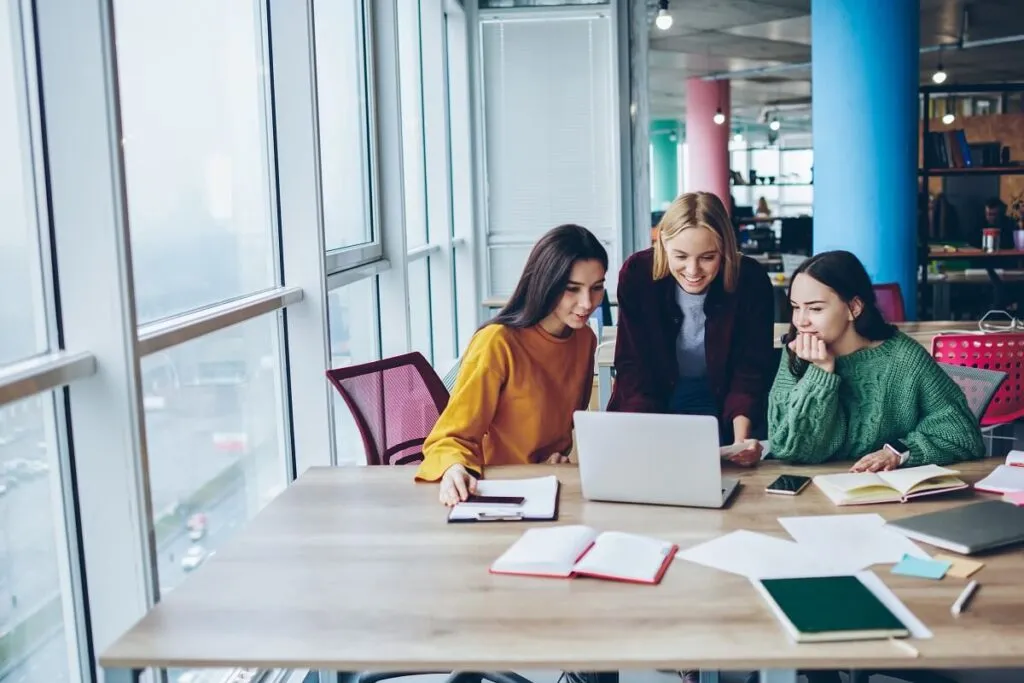 3 mulheres em uma mesa de escritório conversando