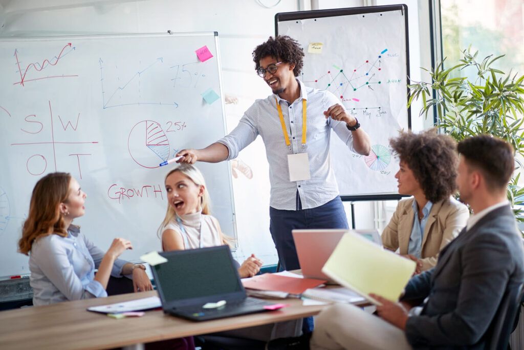 Jovem apresentando pitch para outras 4 pessoas.