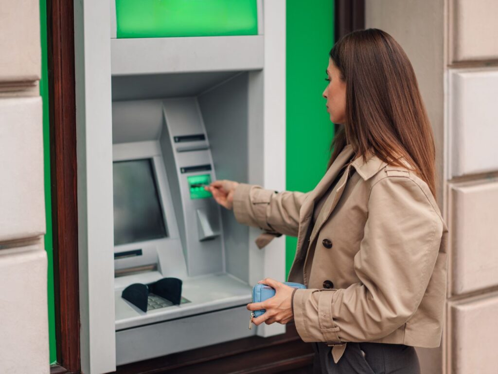 MUlher fazendo saque ATM durante a viagem.
