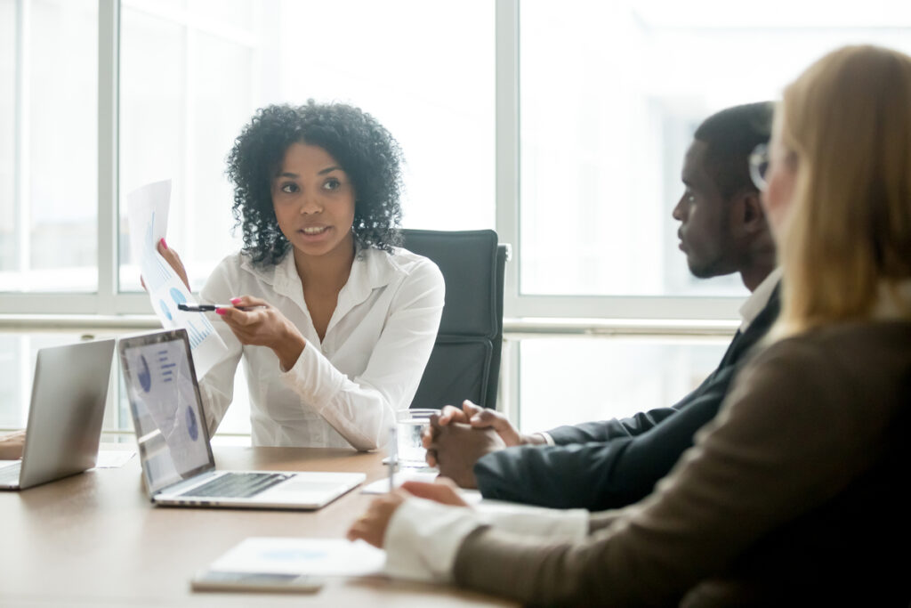Reunião sobre proposta comercial Três pessoas em reunião esclarecendo dúvidas sobre uma proposta comercial.
