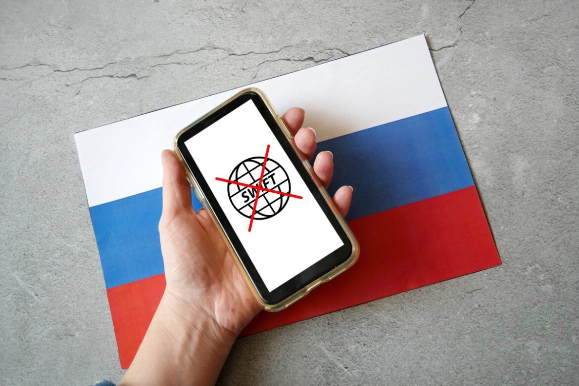 Celular com uma bandeira representando a saída da Rússia do SWIFT.