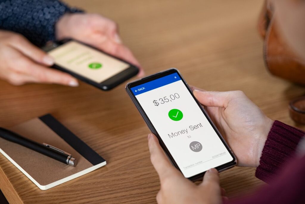 Mulher olhando a tela do smartphone e confirmando o recebimento da transferência pelo MuchBetter.
