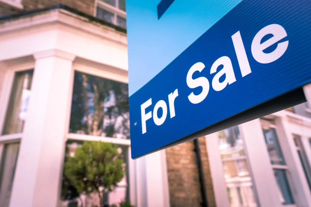 Imagem que mostra placa de vende-se, representando como comprar casa na Inglaterra
