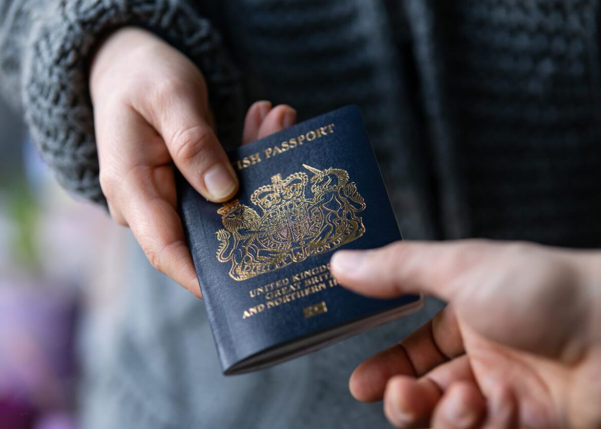 Como conseguir cidadania inglesa: homem entregando passaporte