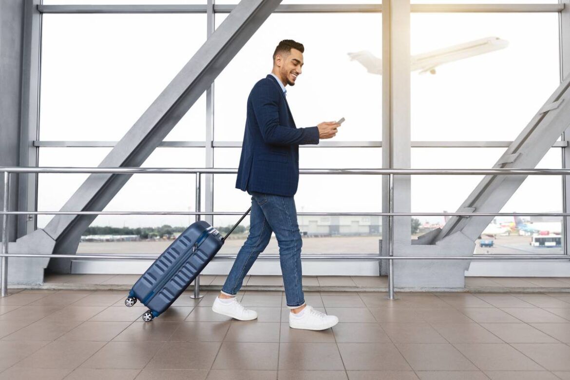 Homem andando com mala em um dos maiores aeroportos do mundo.