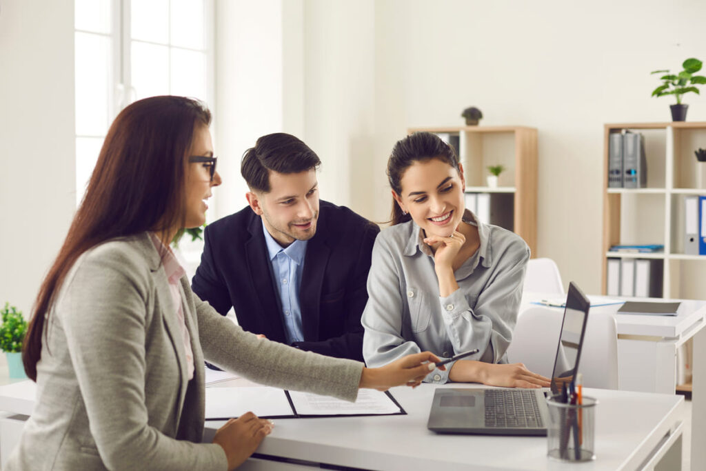 Dois clientes conversam com uma vendedora, aumentando a retenção de clientes.