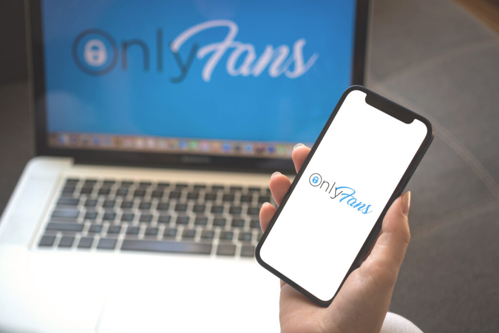 mulher abrindo a plataforma de OnlyFans no celular e no computador para verificar o pagamento através da Remessa Online