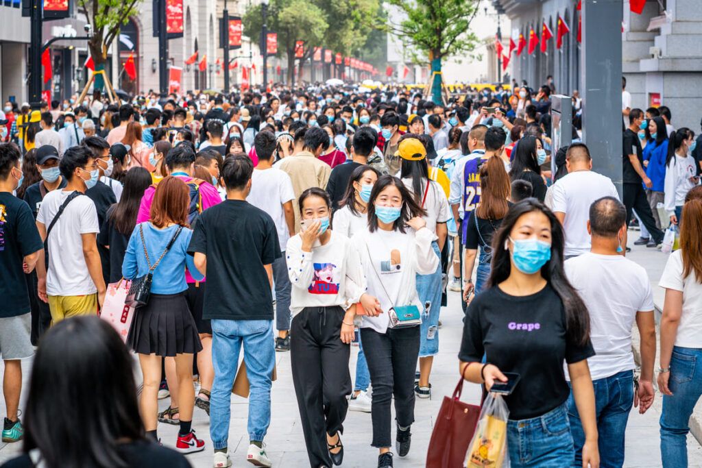 Chineses caminhando em uma avenida