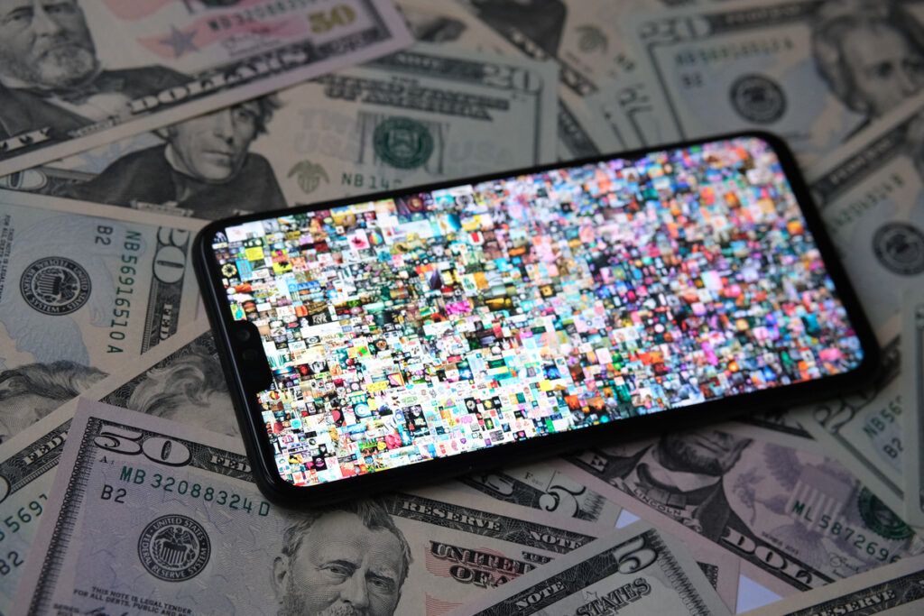 celular em cima das notas de dólar aberto no aplicativo Everyday - The First 5000 Days 