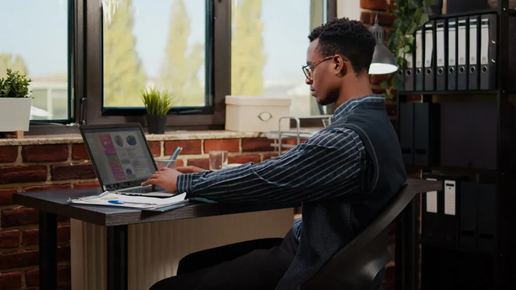 Homem no computador sentado na mesa