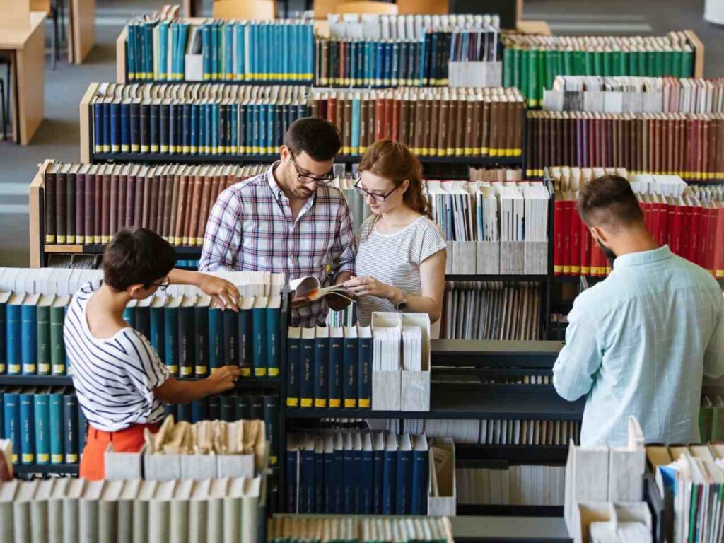Estudantes escolhendo livros na biblioteca