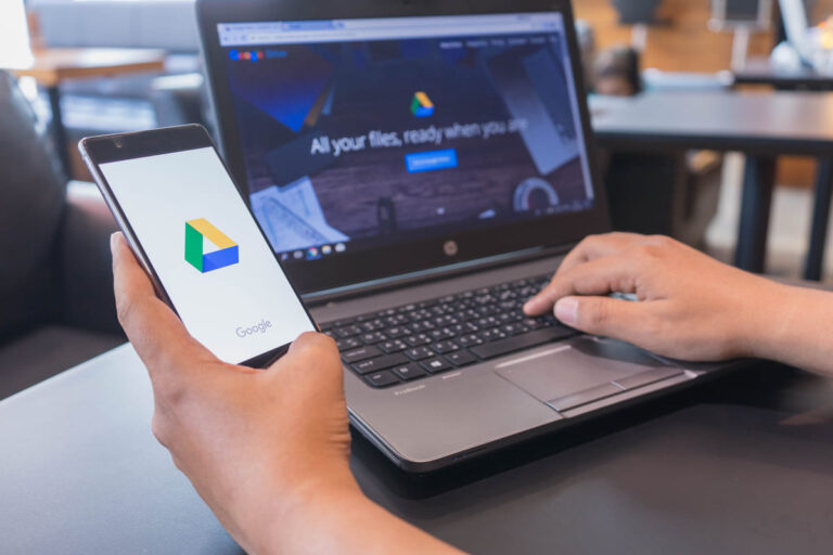 Pessoa utilizando o Google Drive no computador e no celular