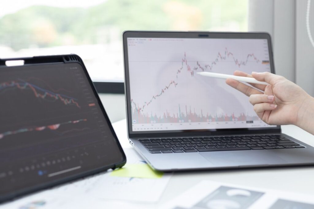 Mulher analisando rating das ações na tela do computador.