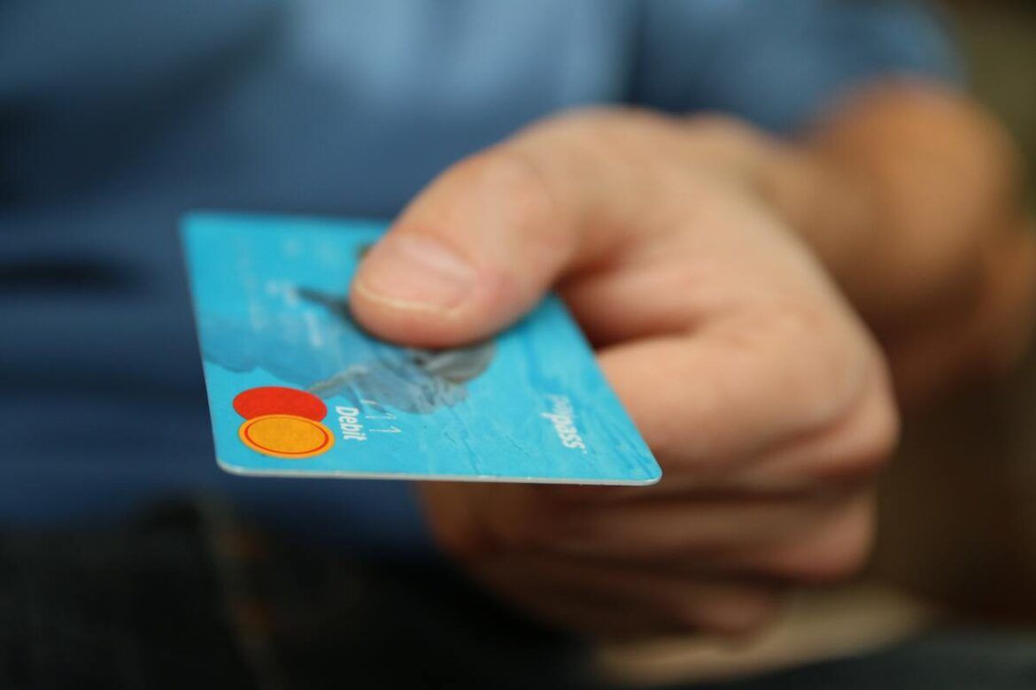 Uma mão segurando um cartão de crédito