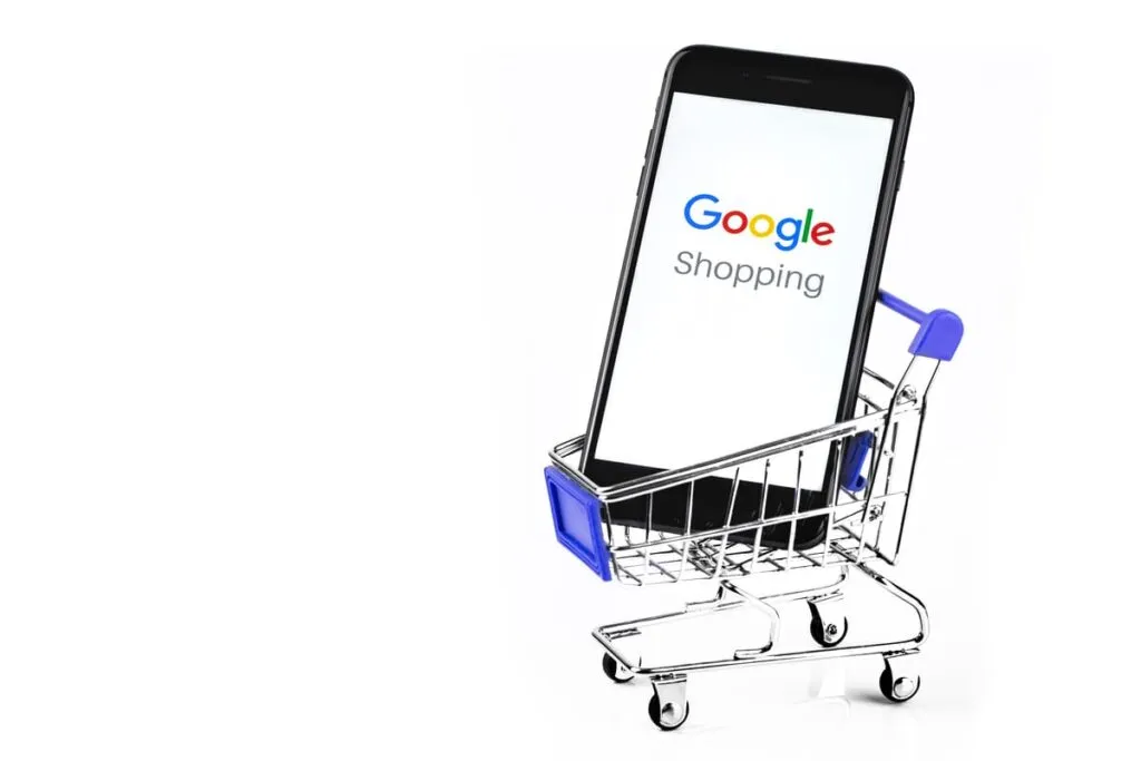 Celular dentro de um carrinho de compras ensinando como investir no Google Shopping