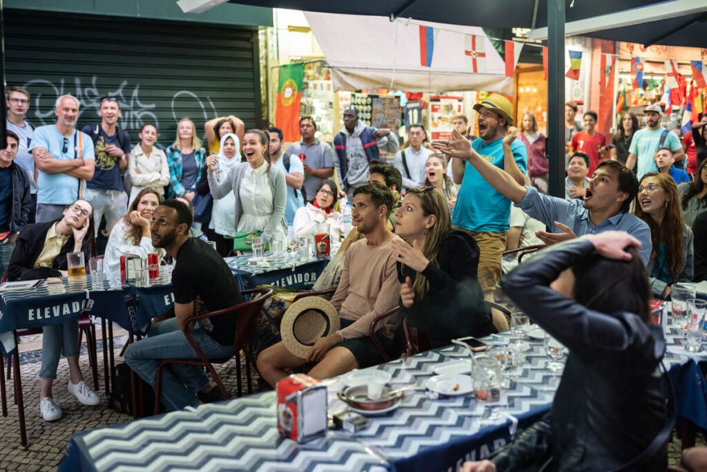 Pessoas assistindo aos jogos da Copa em Lisboa, em um barzinho