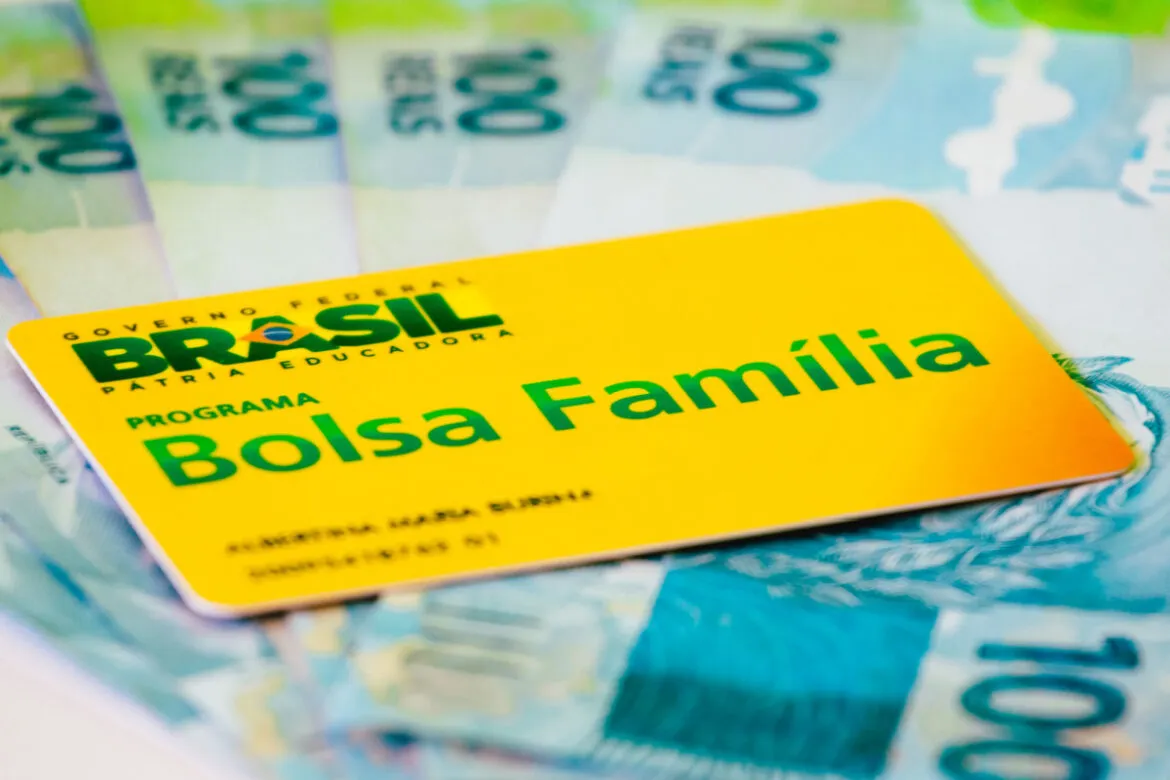 O cartão do Bolsa Família sobre notas de R$ 100 em uma mesa