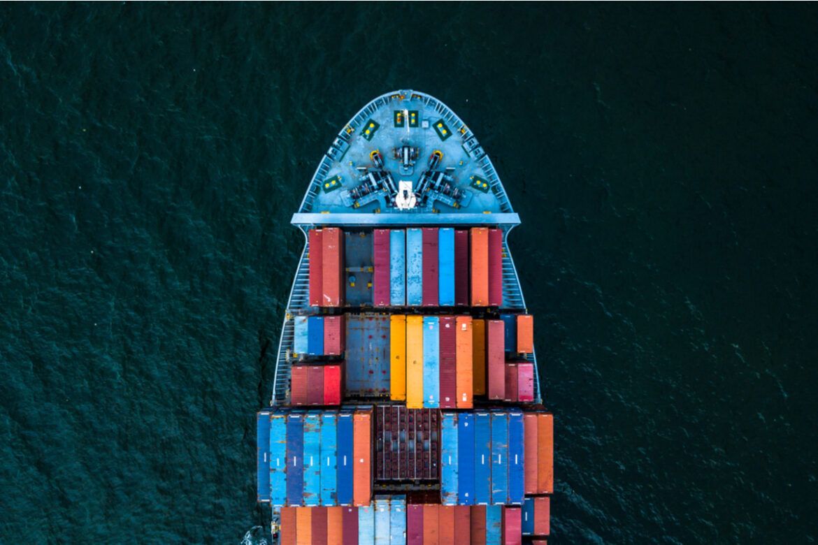 Foto de um navio visto de cima carregando muitos containers