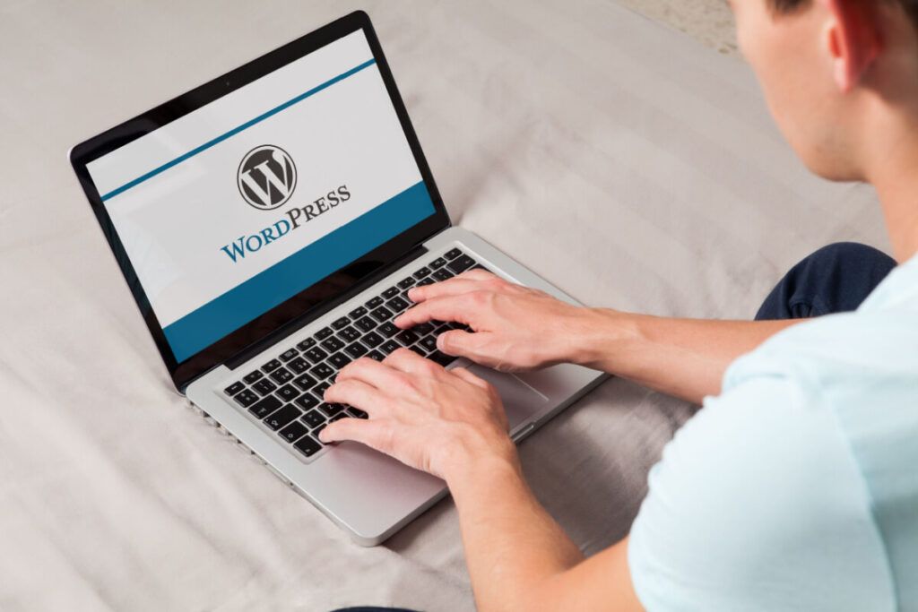 Homem no computador com página inicial do WordPress