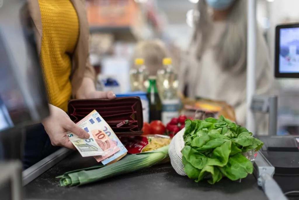 Mulher pagando compras do supermercado no caixa. 