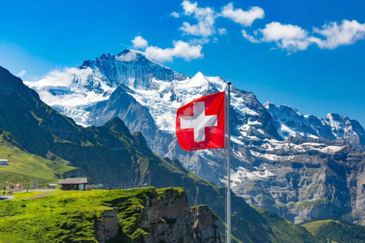 Paisagem com a bandeira da Suíça, onde podem abrir conta na Suíça