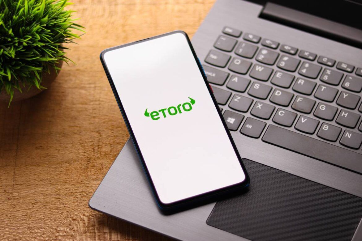 Close-up de smartphone com a tela branca e logo do EToro