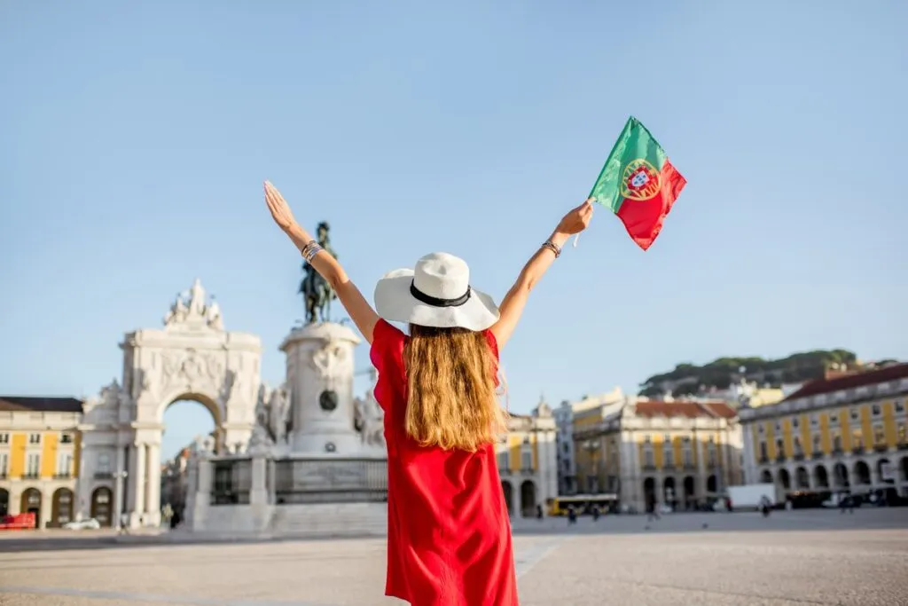 Mulher em Lisboa com vestido vermelho e segurando bandeira de Lisboa
