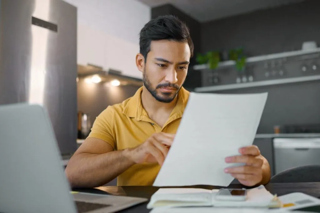 Homem lendo o relatório para declarar o dinheiro no imposto de renda recebido do YouTube. 