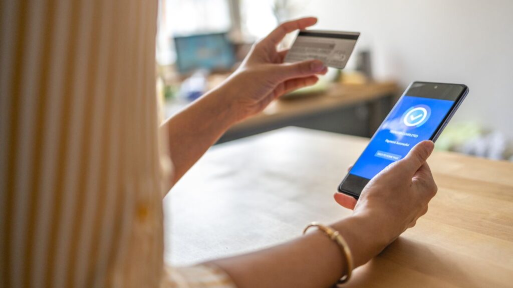 Mulher fazendo pagamento online com cartão.