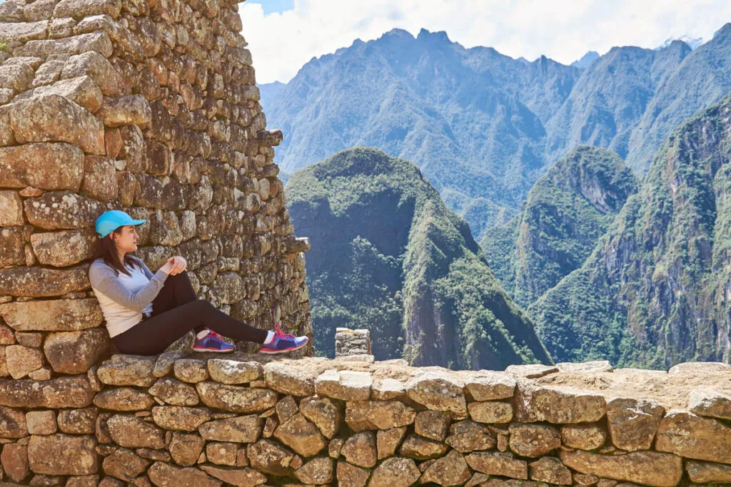 Uma mulher realizando uma visita guiada em Machu Picchu.