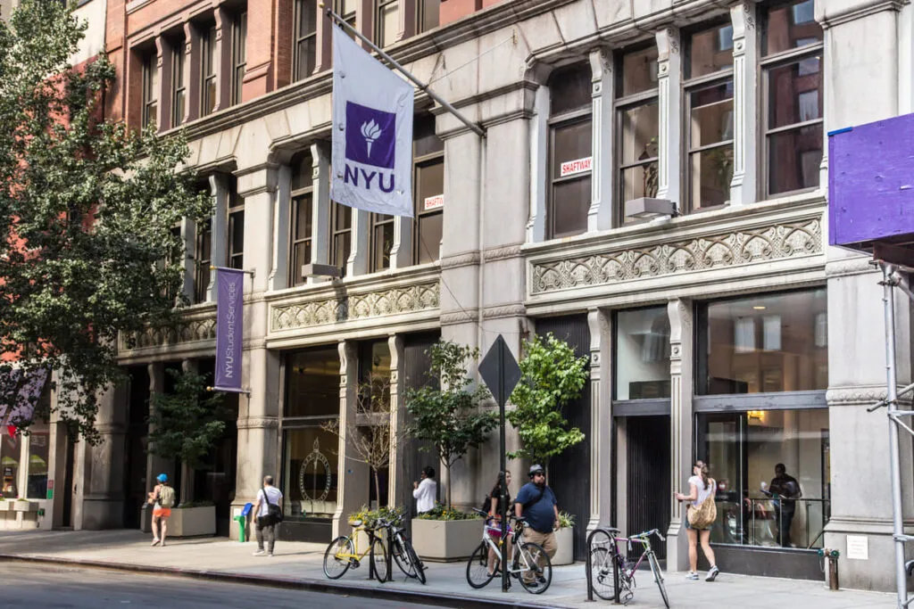Imagem mostra a entrada de um prédio da NYU, no momento em que começam as aulas na universidade.