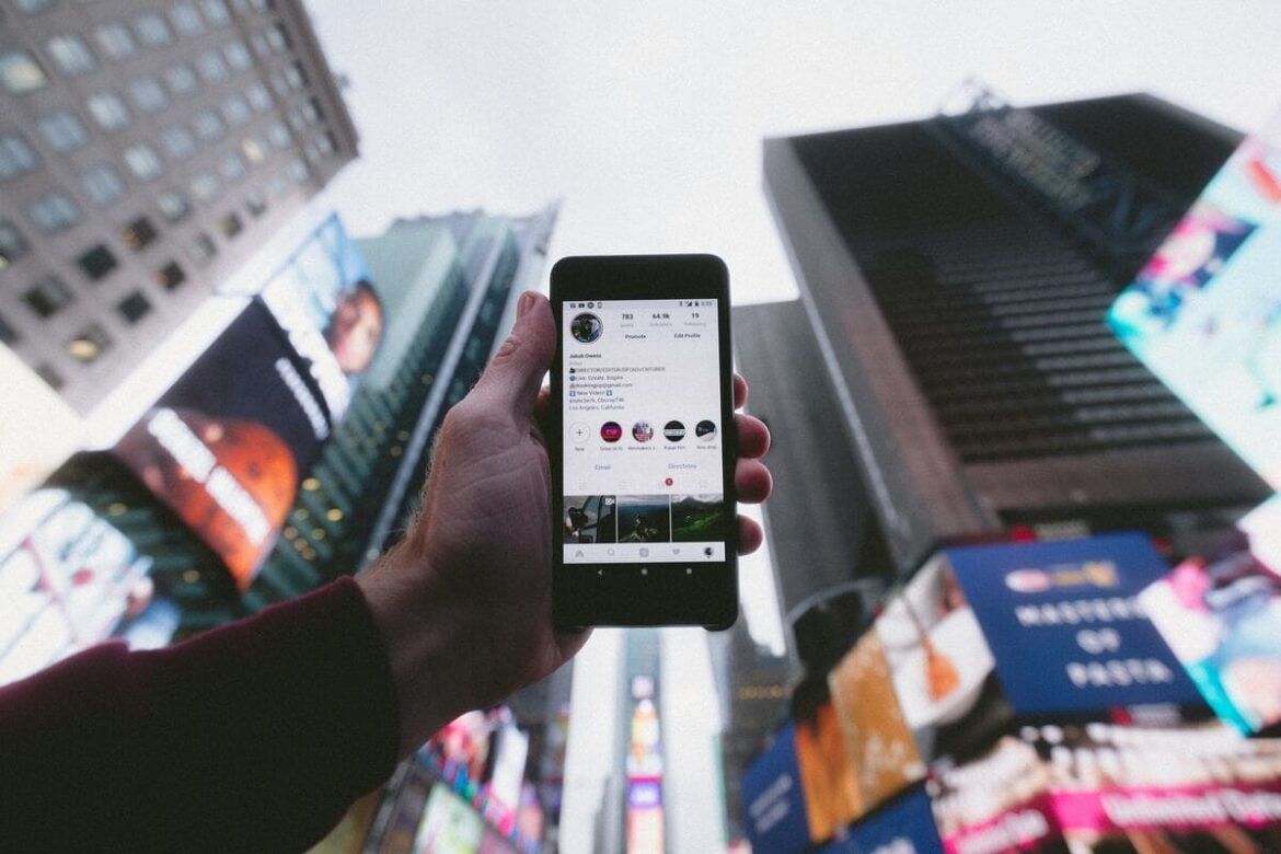Social media olhando seu celular em uma metrópole