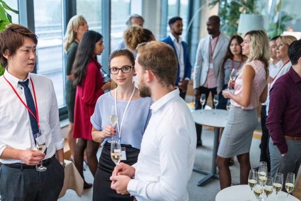 Participantes da conferência conversando durante o evento.