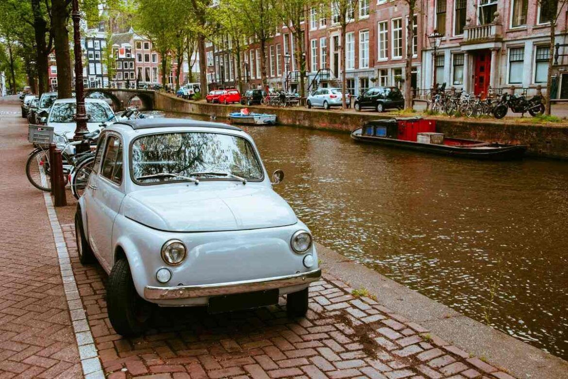 Carro antigo ao lado do canal da cidade de Amsterdã.