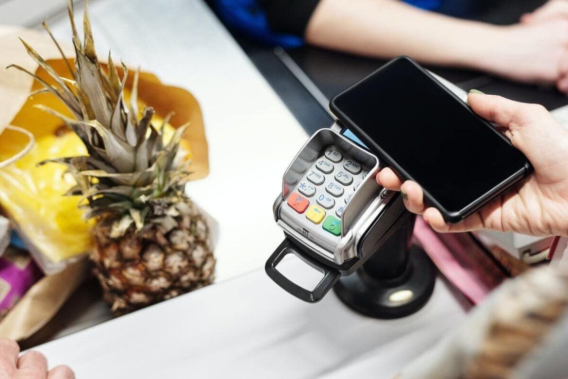 Telefone sendo utilizado para efetuar pagamento por aproximação com o Mercado Pago na carteira digital
