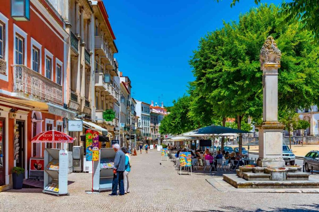 Pessoas caminhando pelas ruas de Alcobaça Portugal em um dia de sol.