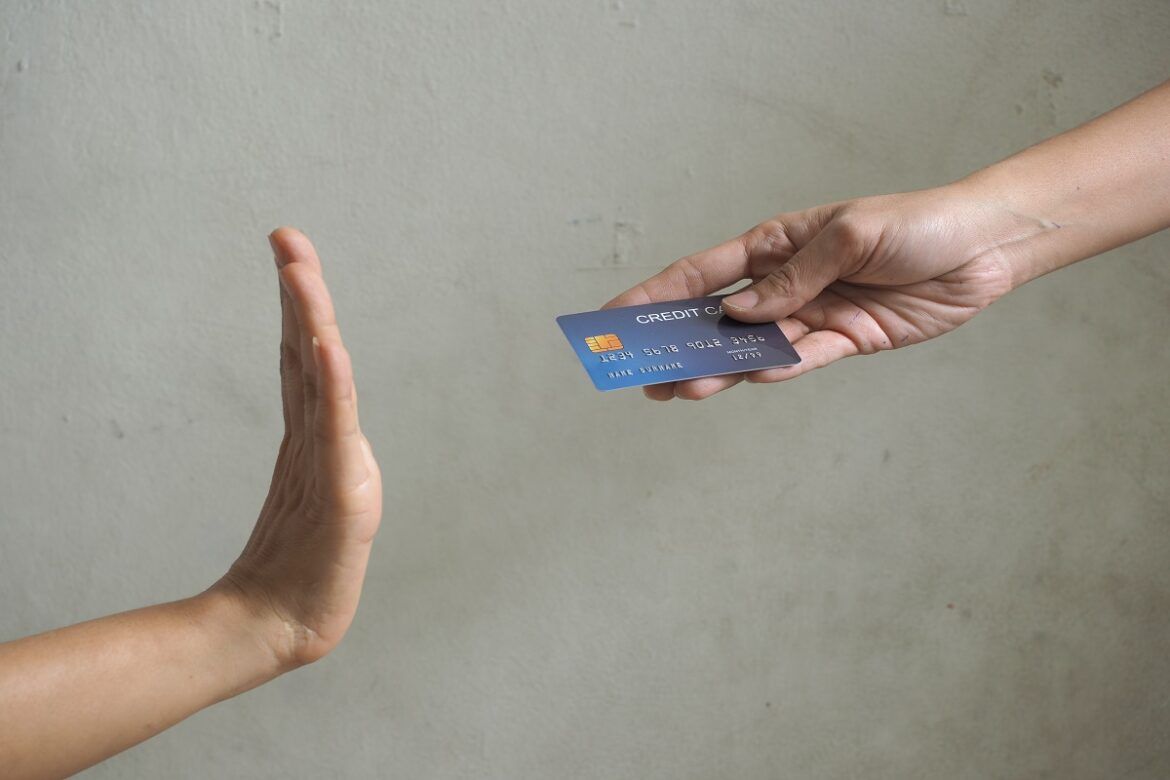 Pessoa dispensando o cartão de crédito para pagar softwares internacionais