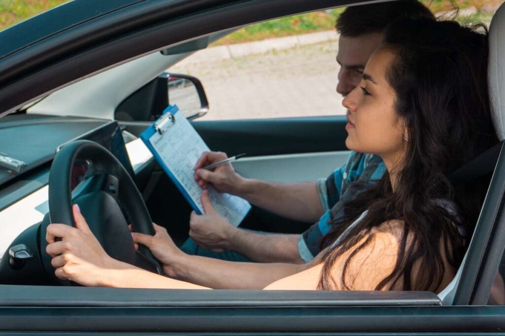 Mulher no carro fazendo prova prática para carteira de motorista na Alemanha.